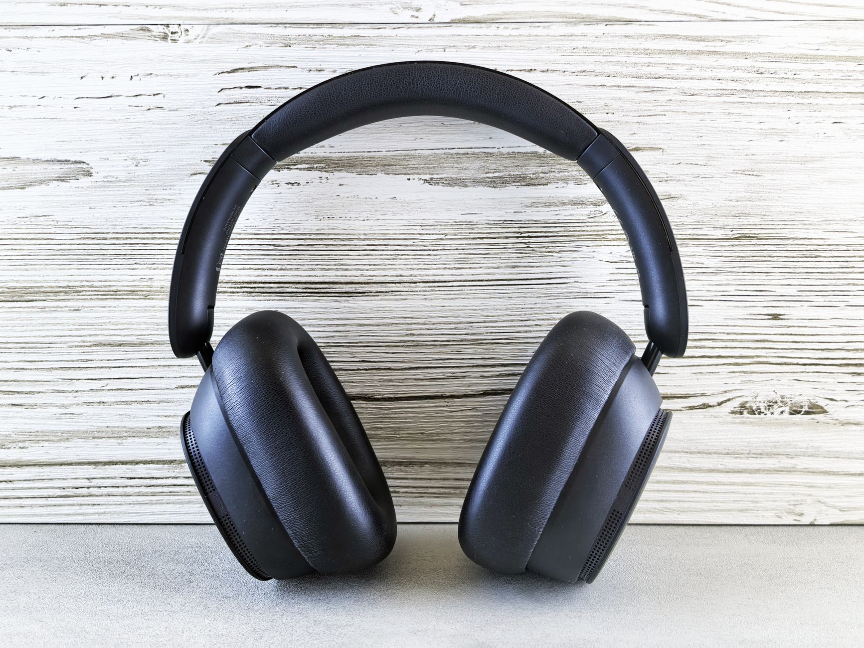 Black over-ear headphones resting on a wooden surface