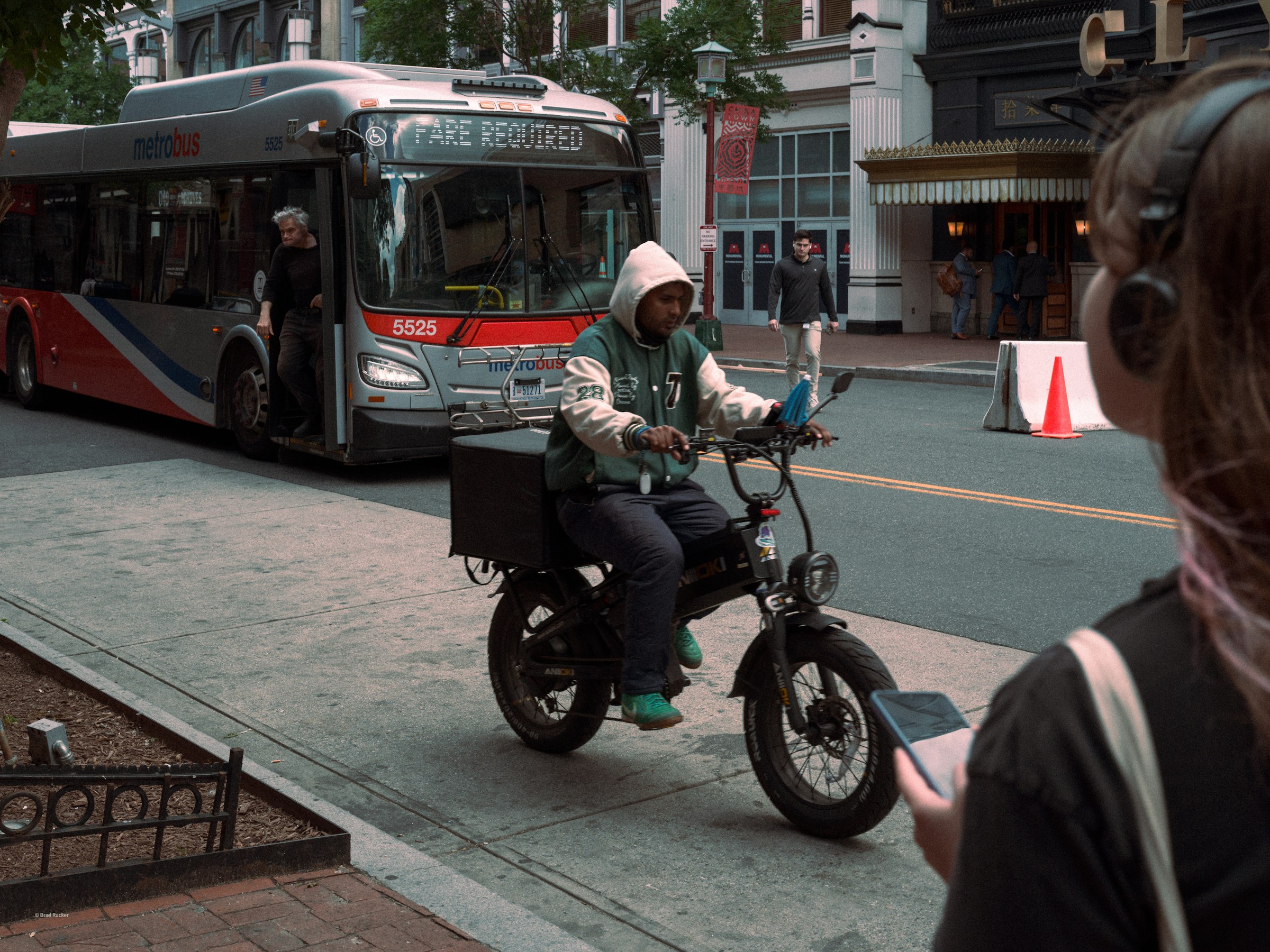 E-bike rider on a city street next to a public bus