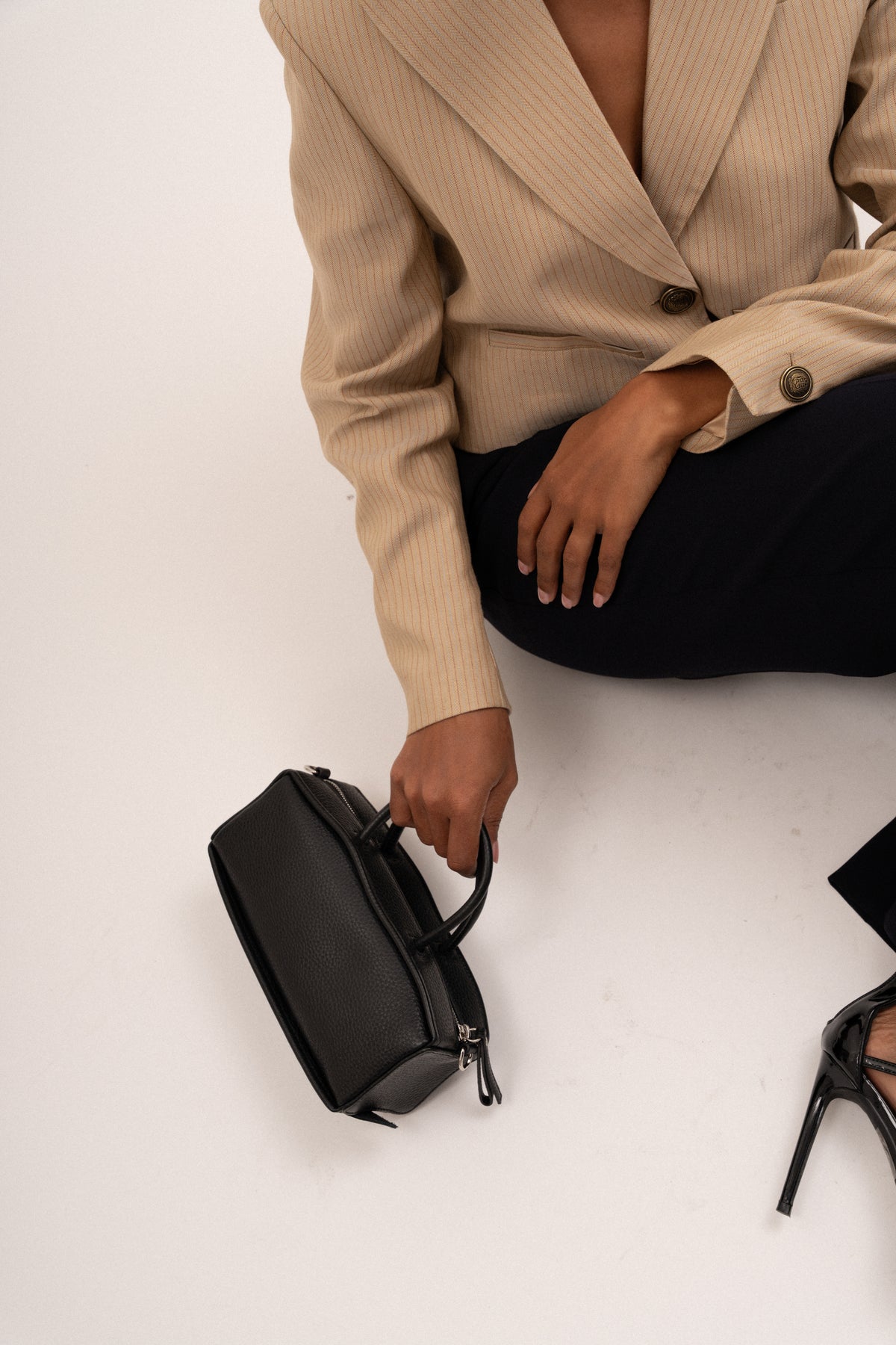 Black Recto handheld bag from Bob Oré's Blue Collection held at someone's side