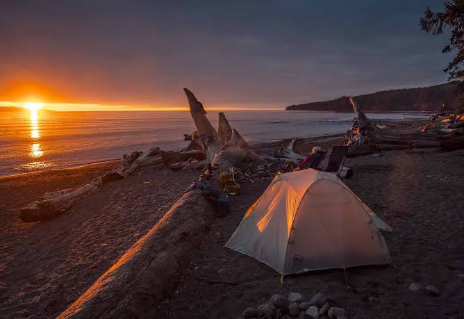 Backpacker pitching a tent at a campsite