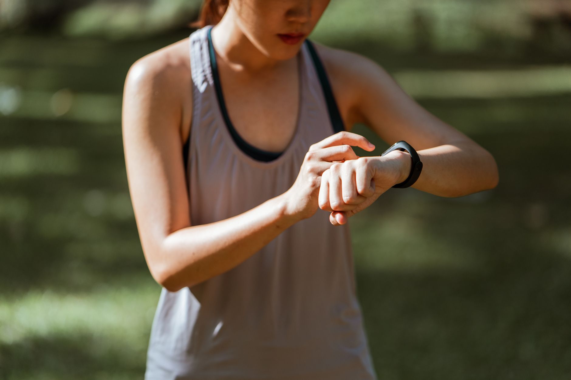 Fit woman checking her fitness tracker outdoors in nature