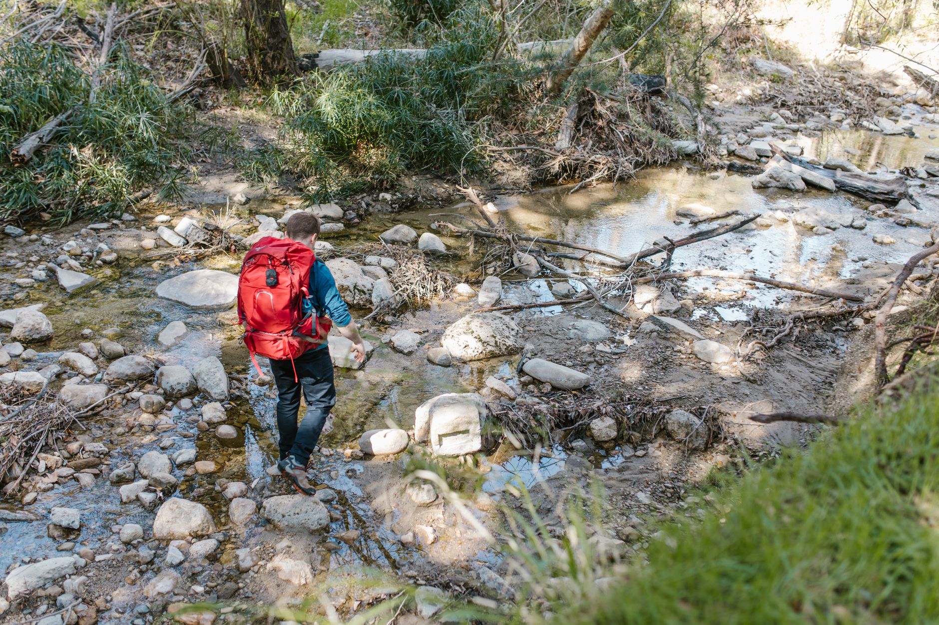 Hiker with a backpack near a stream in the forest