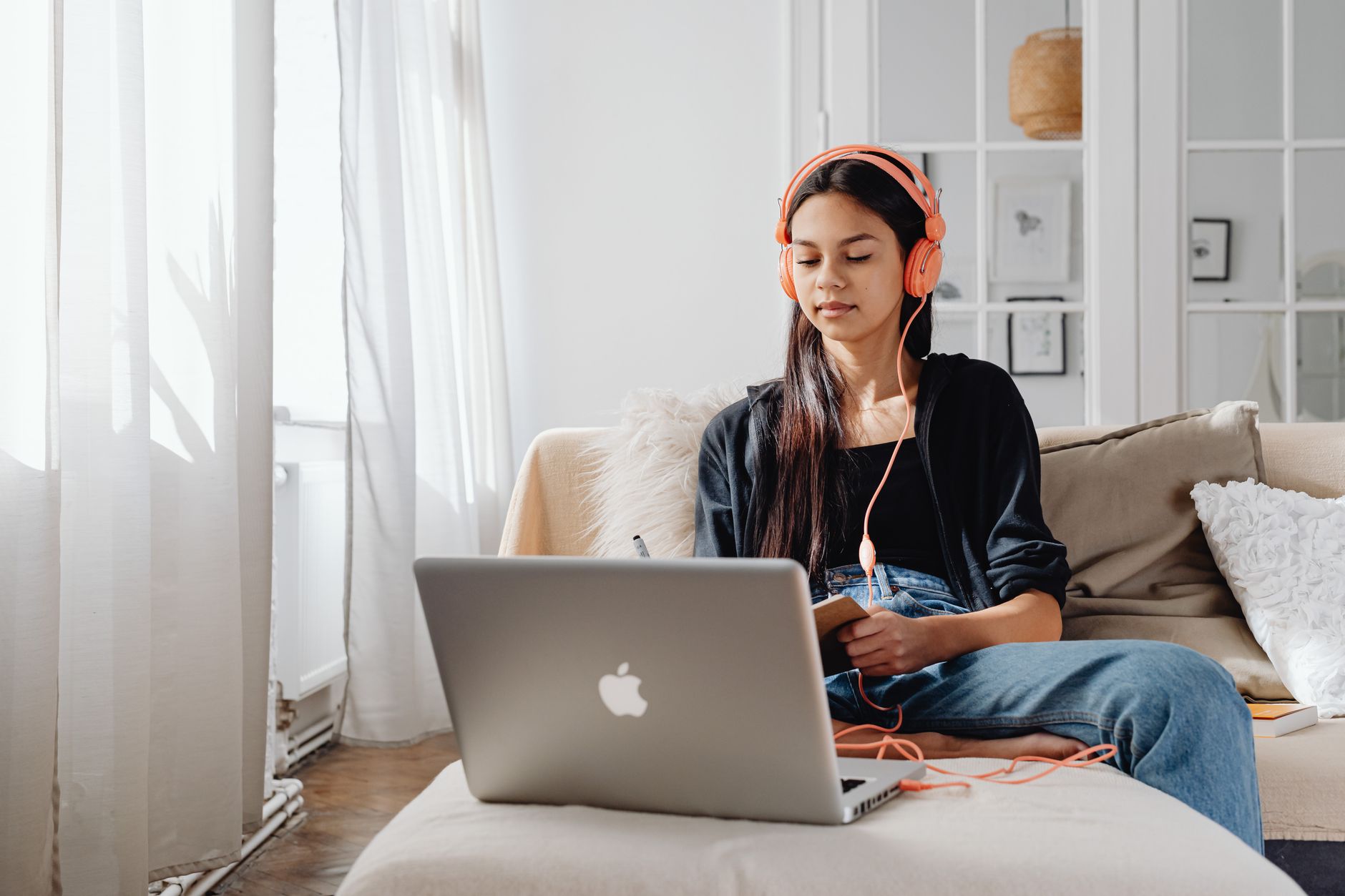 Woman using a laptop while wearing headphones